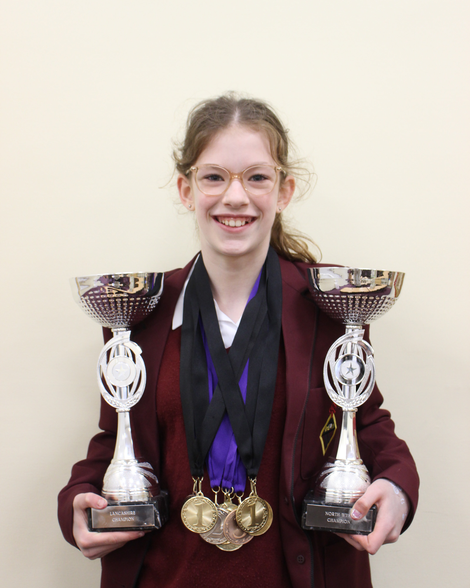Ruby in school with her trophies and medals