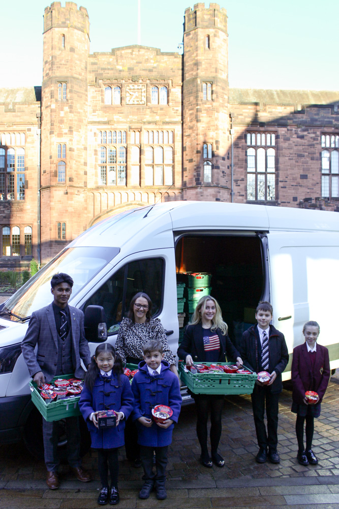 Representatives from Bolton School's Boys' Division, Girls' Division, Beech House, Alumni, Junior Boys and Junior Girls donating Christmas Puddings